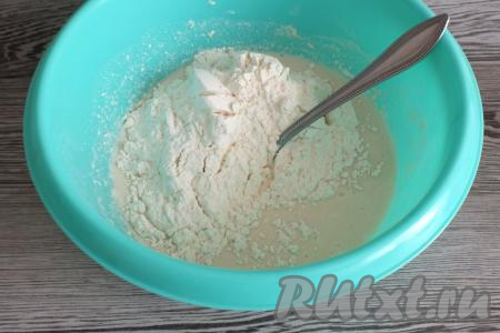 Всыпьте оставшиеся 200 грамм муки, перемешайте, выполняя замес теста вначале ложкой.