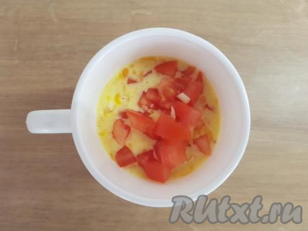 Добавить в кружку натёртый сыр, нарезанные помидор и ветчину (или варёную колбасу).