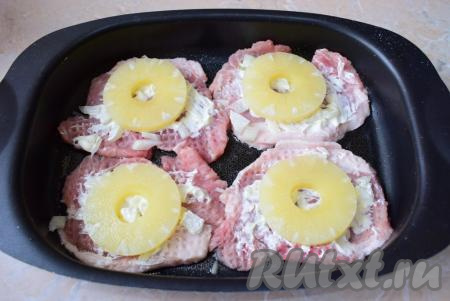 Затем выложите на каждую отбивную по кружочку ананаса.