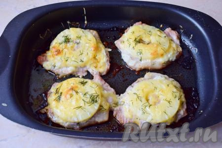 Готовые свиные отбивные, запечённые с ананасами и сыром, немного уменьшатся в размере и подрумянятся. Сыр расплавится и станет слегка золотистого цвета. Извлеките форму из духовки.