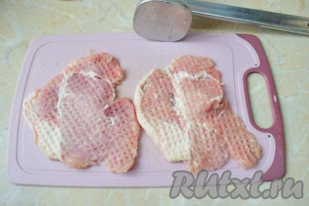 Свинину вымойте, обсушите, а после этого нарежьте на достаточно тонкие порционные кусочки и немного отбейте с помощью кухонного молоточка (не нужно отбивать мясо до прозрачности). Особое внимание обратите на толщину отбивных, кусочки не должны быть толстыми, так как запекать мы будем мясо в духовке непродолжительное время и свинина за это время должна полностью приготовиться.