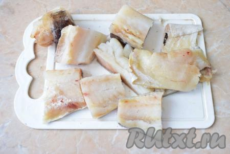 Филе трески необходимо разморозить при комнатной температуре (если у вас целая рыбка, тогда немного разморозьте её, удалите внутренности и чёрную плёночку из брюшка, срежьте все плавники и хвост, промойте, а затем аккуратно отделите филе, удаляя хребет и кости). Затем нарежьте размороженную рыбу на порционные кусочки, промокните её бумажным полотенцем от излишков влаги.