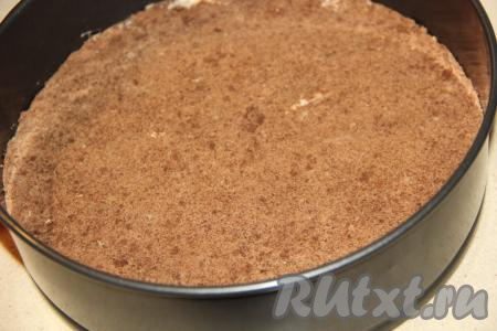 Разделить массу на две части (та часть, которая будет нижним коржом, должна быть немного больше). В форму для выпечки (у меня разъёмная форма диаметром 25 см) выложить часть крошки, предназначенную для нижнего коржа (эта часть крошки немного больше оставшейся), и утрамбовать. Поставить на 30 минут в холодильник.&nbsp;