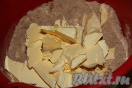 В смесь сухих ингредиентов добавить холодное масло (или маргарин), нарезанное на небольшие кусочки.
