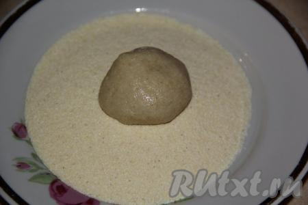 Влажными руками, отщипнув небольшое количество теста, сформировать шарик размером с грецкий орех. Обвалять шарик в манке со всех сторон. Аналогично сформировать все шарики, обваленные в манке, из оставшегося теста.