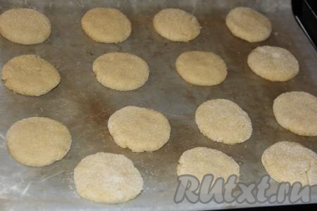 Противень застелить пергаментом (или тефлоновым ковриком) и выложить шарики, обваленные в манке, на расстоянии друг от друга. Слегка шарики приплюснуть.