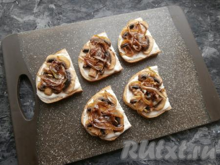 Выложить жареные пластины шампиньонов на смазанные ломти батона, а сверху разложить карамелизированный лук.