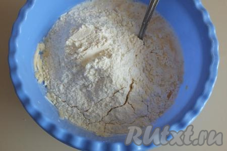 Всыпьте 1,5 стакана муки, начните тесто перемешивать ложкой.