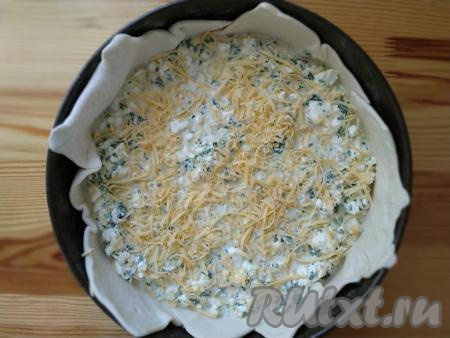 Сверху на тесто выкладываем подготовленную начинку из курицы и шпината, сверху равномерно посыпаем половиной натёртого сыра. Затем равномерно заливаем сметанно-яичной заливкой и присыпаем оставшимся сыром. При желании, украшаем кунжутными семечками.