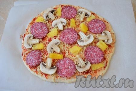 Откройте баночку консервированных ананасов и нарежьте ананасы на тонкие кусочки. Выложите нарезанные ананасы на пиццу.