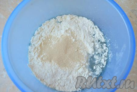 Муку просейте через сито, чтобы насытить её кислородом. Всыпьте в миску с водой и маслом большую часть просеянной муки (примерно 2/3 от общего объёма) и сухие дрожжи, начните замешивать тесто для пиццы. Вначале это удобно делать деревянной лопаткой. А когда тесто станет достаточно густым, можно замешивать руками.