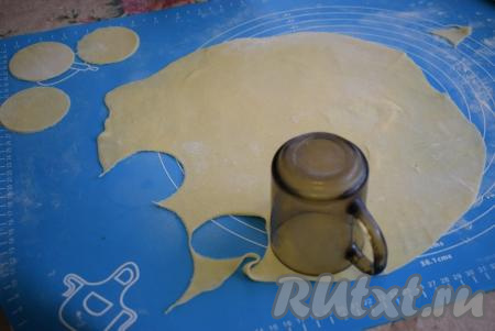 Далее делим тесто на 4 равные части. На поверхности, присыпанной мукой, раскатываем каждую часть теста в достаточно тонкий пласт. При помощи кружки (или рюмки, или формочки) вырезаем кружочки-заготовки для наших вареников. Остатки теста от каждого пласта собираем в комок и, размяв его, раскатываем в пласт и вырезаем кружочки. В среднем выход вареников по данному рецепту 70-80 штук, в зависимости от размера.