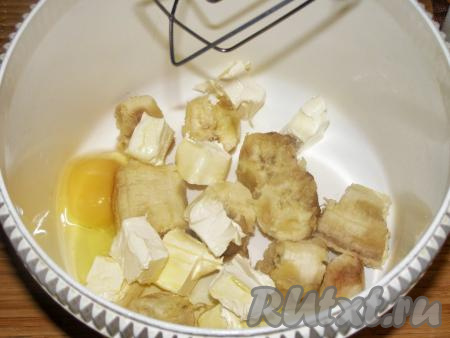 Для приготовления этого печенья лучше брать зрелые, мягкие бананы. Масло нужно заранее достать из холодильника и дать ему полежать при комнатной температуре около часа, чтобы оно стало мягким. Банан очищаем, разламываем на кусочки и выкладываем в чашу миксера, добавляем кусочки мягкого сливочного масла и яйцо, перемешиваем на низкой скорости миксера до однородного состояния.