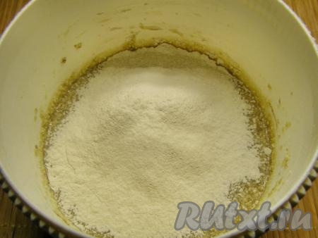 Понемногу всыпаем просеянную муку и замешиваем тесто сначала ложкой, а затем продолжаем вымешивать руками.