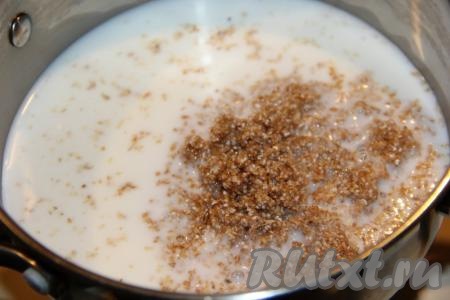 Когда молоко с водой закипят, добавить промытую пшеничную крупу в кастрюлю, перемешать.