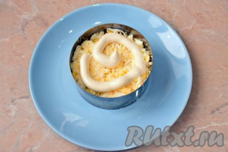 Варёные куриные яйца очистите от скорлупы и, натерев на крупной тёрке, выложите следующим слоем поверх курицы, не забудьте смазать майонезом.