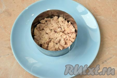 Я решила сформировать салат порционно. Остывшее куриное мясо мелко нарежьте, выложите первым слоем на дно формы и немного прижмите, чтобы оно лежало плотнее. Этот слой и все последующие немного смазывайте майонезом.