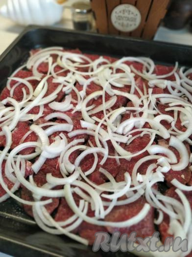 Лук очищаем, нарезаем достаточно тонкими полукольцами и равномерно распределяем поверх говядины.