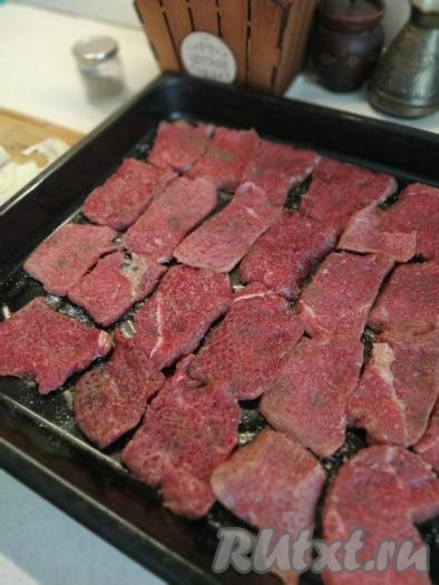 Выкладываем мясо на противень в один слой, солим и перчим по вкусу.