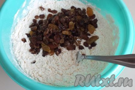 Начните перемешивать тесто вилкой. Затем добавьте обсохший изюм и замесите тесто руками.