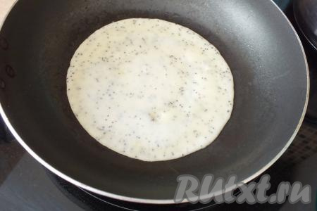 На сковороду налейте 1 столовую ложку&nbsp;растительного масла, разогрейте. Наберите в половник блинное тесто, вылейте в сковороду и распределите его по дну. Жарьте блин на огне чуть меньше среднего, пока верх теста не затянется плёночкой и тесто перестанет быть жидким.