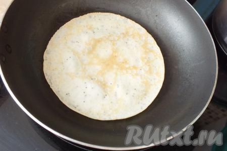 Переверните блинчик с маком и обжаривайте с другой стороны ещё 2-3 минуты. Огонь держите чуть меньше среднего. Готовый блинчик переложите на тарелку, смажьте сливочным маслом. Перед жаркой последующих блинчиков сковороду маслом можно не смазывать.