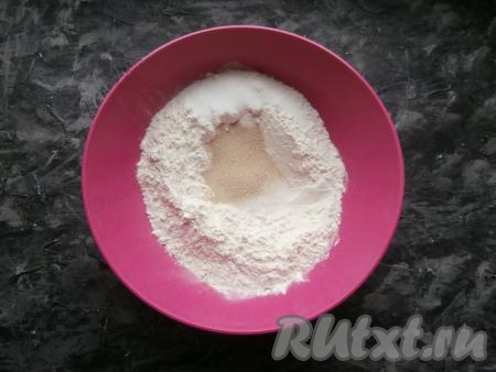 Просеять муку в миску, в центре сделать небольшое углубление. В это углубление всыпать сахар, сухие дрожжи и соль.