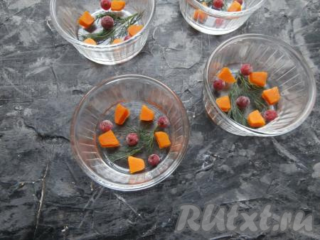 Я готовила холодец в кокотницах. На дно кокотниц разложить нарезанную кусочками варёную морковку, ягоды смородины (по желанию) и веточки укропа.