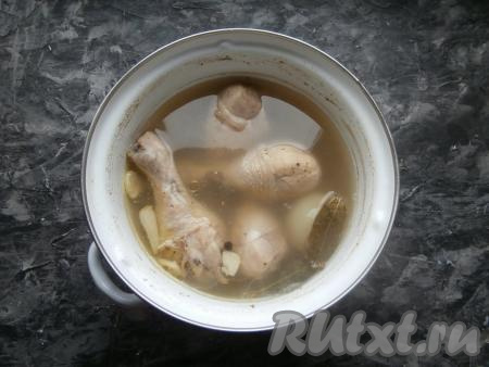 Поставить кастрюлю на огонь, после закипания снять пену, воду посолить по вкусу и добавить горошины чёрного перца. Далее варить холодец из ножек&nbsp;около 1-1,5 часов под прикрытой&nbsp;крышкой. Через 20-25 минут луковицу удалить из бульона. За 15 минут до готовности добавить в кастрюлю лавровые листья и нарезанный крупно чеснок. Дать бульону с куриными голенями остыть до тёплого состояния без крышки.