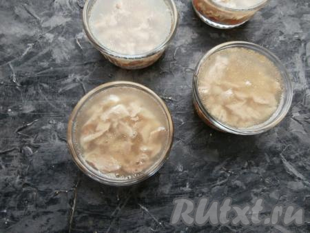 Теперь разложить мясо по кокотницам и залить охлаждённым бульоном. Поставить холодец до полного застывания в холодильник.