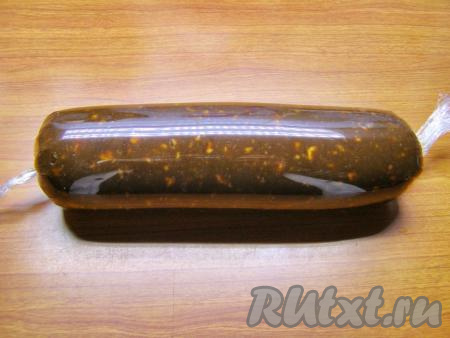 Сворачиваем плёнку, формируя колбаску из смеси печенья и какао, затем с одной стороны завязываем узелок. С другого края сдвигаем шоколадную массу к узелку, чтобы удалить лишний воздух. Завязываем узел с другой стороны. Оставляем шоколадную колбаску, завёрнутую в плёнку, остыть до комнатной температуры, затем убираем в холодильник минимум на 3-4 часа, чтобы десерт застыл.