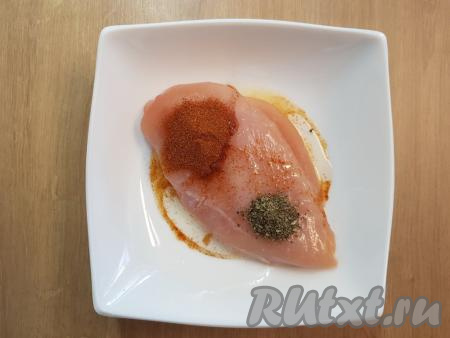 В глубокую тарелку выложить куриное филе. Далее поверх филе необходимо насыпать соль по вкусу, добавить лимонный сок, растительное масло, молотую сладкую паприку и сушёные травы (я добавила сушёный базилик, можно добавить и специи по вкусу).