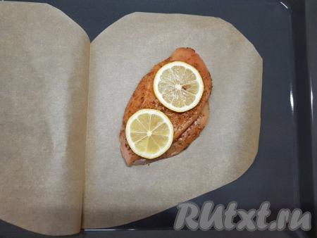 По прошествии времени по середине одной из половинок&nbsp;листа пергаментной бумаги выложить замаринованное куриное филе. Поверх филе разложить 2 кусочка лимона.