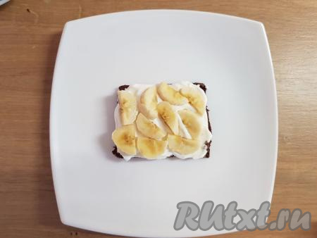 Сверху корж смазать 1 чайной ложкой с горкой мягкого творога, сверху выложить слой из кусочков банана.