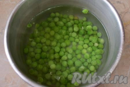 Если зелёный горошек свежий, то его можно сразу добавлять в блюдо. Если замороженный - необходимо, не размораживая его, выложить в кипящую воду, дать закипеть, а затем проварить 4-5 минут и слить лишнюю воду.