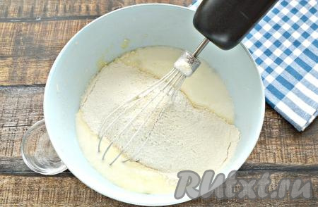 В кефирную смесь просеять пшеничную муку вместе с разрыхлителем.