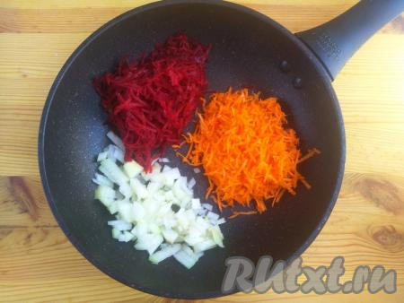 Свеклу и морковь вымыть, очистить от кожуры и натереть на средней тёрке. Лук очистить от шелухи, нарезать небольшими кусочками. Выложить морковку, свеклу и лук в сковороду, добавить растительное масло, перемешать и обжаривать на умеренном огне минут 7-10, не забывая помешивать время от времени.