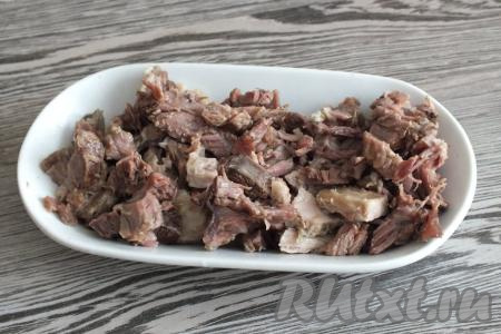 По истечении времени проверьте готовность крупы (она должна стать достаточно мягкой). Суповой&nbsp;набор достаньте из бульона, охладите мясо и, отделив его от костей, нарежьте небольшими кусочками.