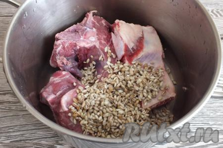 С утра крупу промойте в нескольких водах (до прозрачности). Возьмите достаточно объёмную кастрюлю, выложите в неё говяжий суповой набор и промытую перловку.