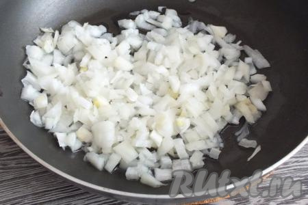 Очищенную луковицу нарежьте достаточно мелко, выложите на сковороду, хорошо разогретую с растительным маслом. Обжарьте лук на среднем огне до мягкости (на это потребуется минут 5), не забывая помешивать.