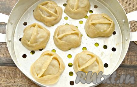 Поместить поддон с мантами в кастрюлю с кипящей водой и готовить манты с капустой и фаршем в мантоварке над паром 45 минут. Можно приготовить манты и в мультиварке на режиме "На пару".