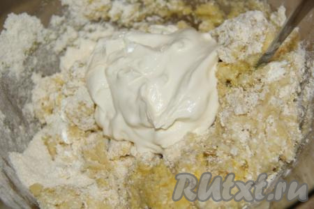 Перемешать получившееся тесто столовой ложкой, добавить сметану, ещё раз тщательно перемешать.