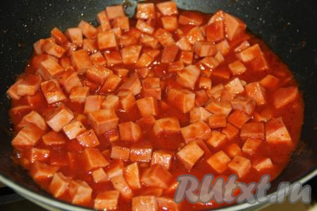 Перемешать колбасу с томатным соусом, дать закипеть, а затем потомить на небольшом огне пару минут.