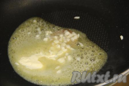 В сковороду с высокими бортиками выложить сливочное масло и растопить. Чеснок почистить, нарезать на мелкие кубики, выложить в растопленное масло и обжарить в течение&nbsp;минуты, помешивая, на среднем огне.