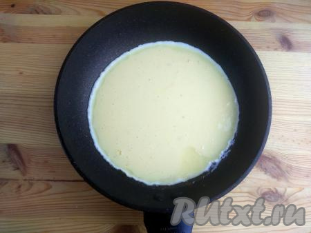 На сковороду налить, примерно, 1 столовую ложку растительного масла, раскалить на сильном огне, вылить яично-кефирную смесь. Накрыть сковороду крышкой, огонь убавить до минимума. Готовить омлет в течение 5-7 минут. На поверхности не должно быть сырой массы. Во время запекания омлет сильно поднимается.