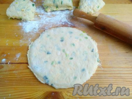 Затем разделить тесто на 4 части, каждую часть раскатать на присыпанной мукой твёрдой поверхности в лепёшку. Толщина лепёшки 1,5-2 мм. Обрезать края по тарелке.