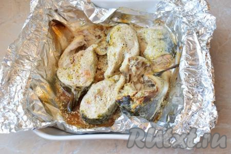 Готовую рыбу извлеките из духовки, снимите с неё фольгу и переложите на тарелку.