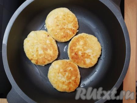 Жарить лепёшки с колбасой и сыром на сковороде под крышкой с двух сторон на небольшом огне до золотистого цвета (примерно, по 5 минут с каждой стороны).