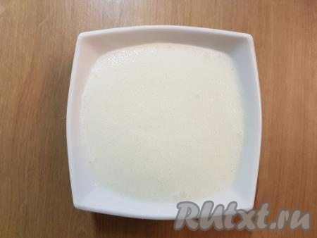 В отдельную тарелку налить кефир, добавить к нему соду и хорошо перемешать (на поверхности кефира должны появиться пузырьки).