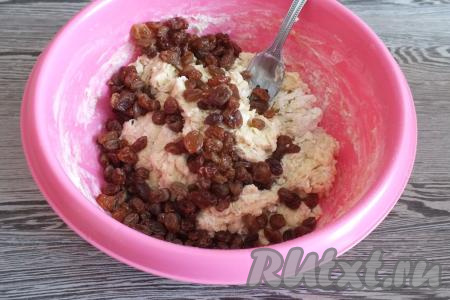 Добавьте изюм и далее замешивайте тесто руками. Тесто получается липнущим, поэтому обсыпьте руки 1-2 столовыми ложками муки - так удобнее собрать тесто в комок.